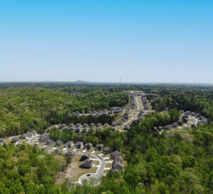 drone shot of a beautiful blue sky and single family community surrounded by trees